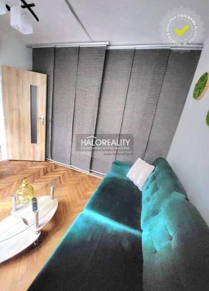 Living room with a turquoise sofa, wooden-patterned floor, and a coffee table.