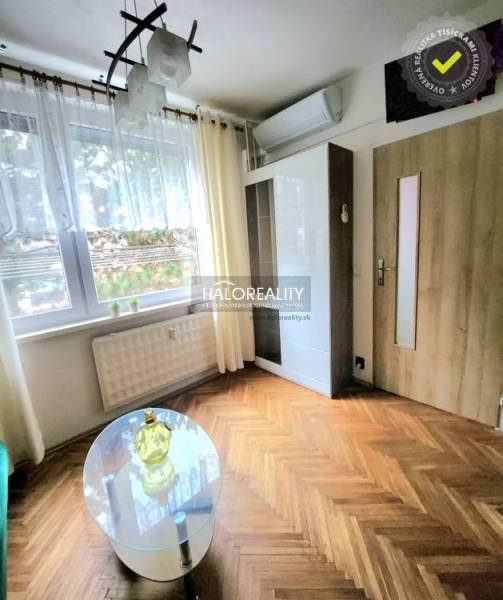 Interior of a 1-room apartment with installed air conditioning and wooden decor flooring.
