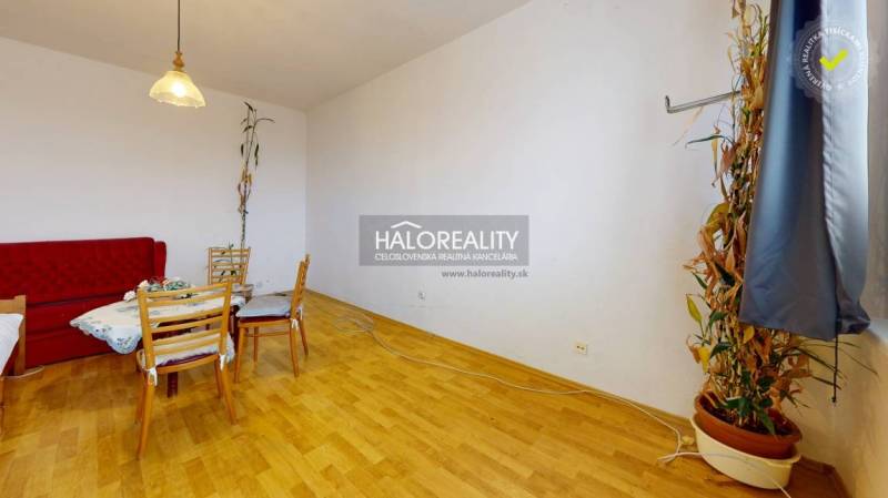 Dining table with wooden chairs in the living room of a three-room apartment with a wooden decor floor.