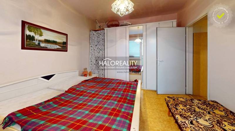 A bedroom in a 3-room apartment with a bed, a wardrobe, and a picture on the wall.