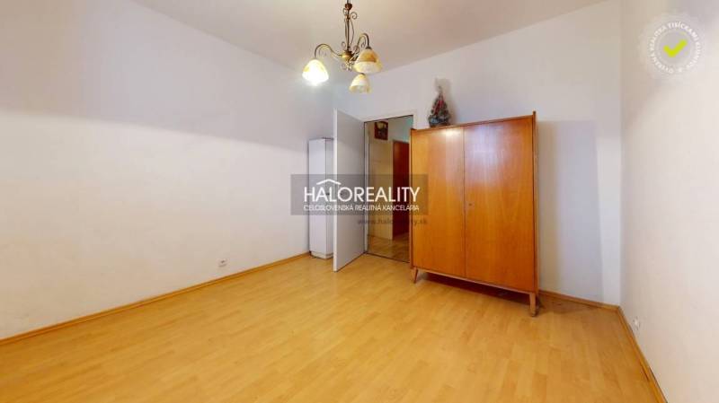 A room in a 3-room apartment with a closet and a floor with a wooden decor.