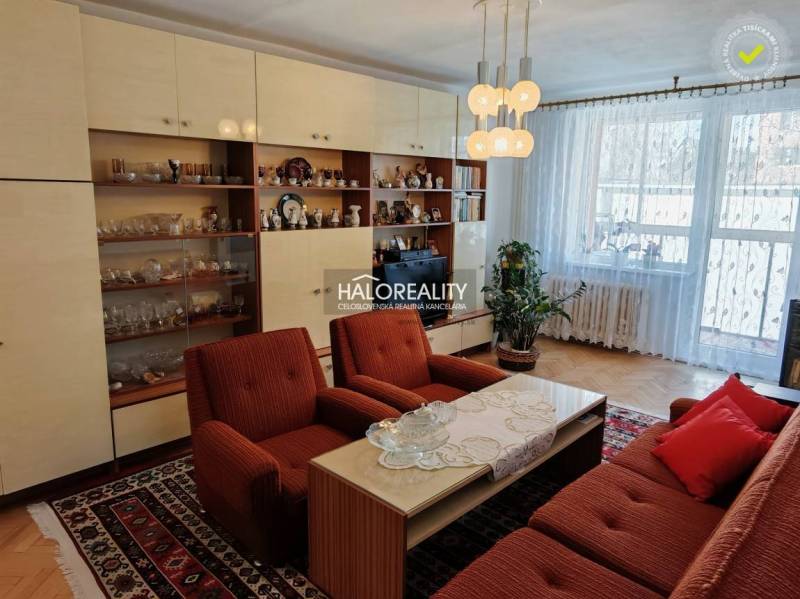 Living room in a three-room apartment with a wooden decor floor and retro furniture.