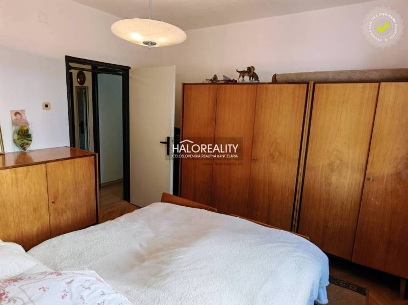 A bedroom in a 3-room apartment with wooden wardrobes and a ceiling lamp.