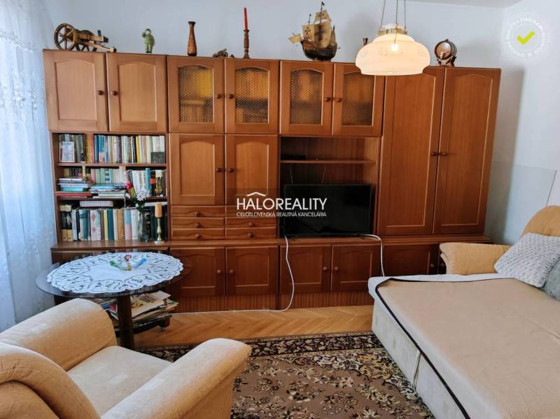Living room in a 3-room apartment with wooden furniture and a floor with a wood design.