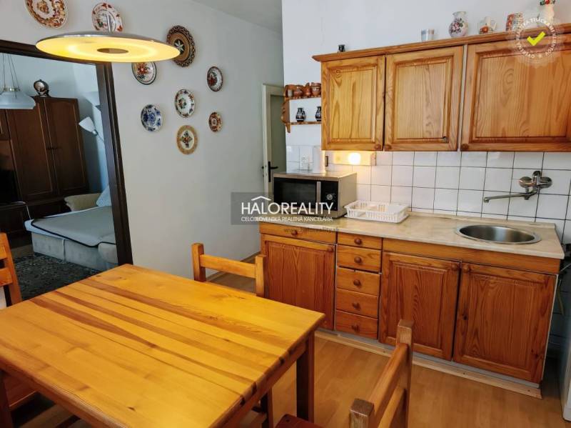 Dining room in a 3-room apartment with a kitchen unit and wooden decor furniture.