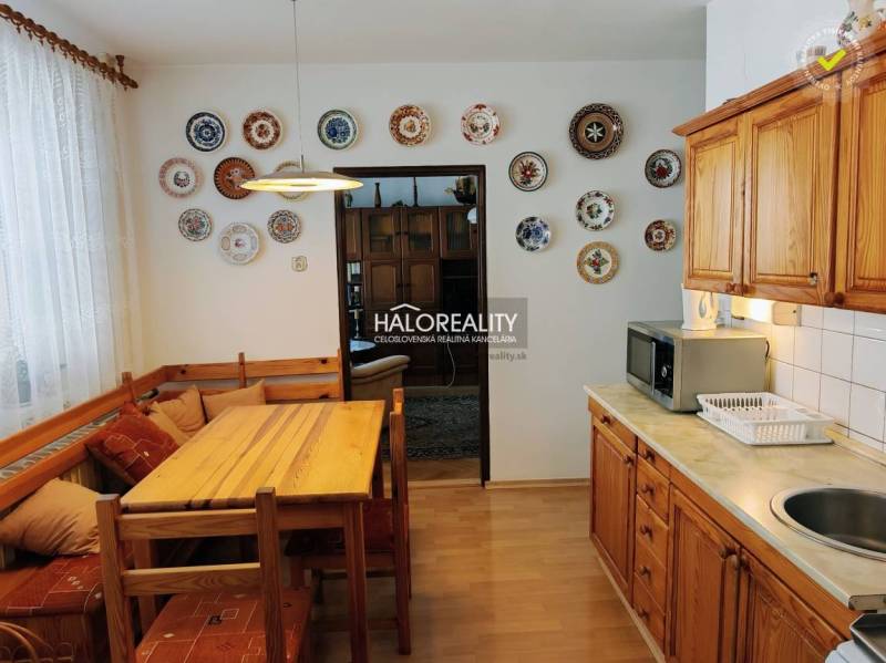 A kitchen in a 3-room apartment with a wall decorated with plates and a floor with a wooden decor.