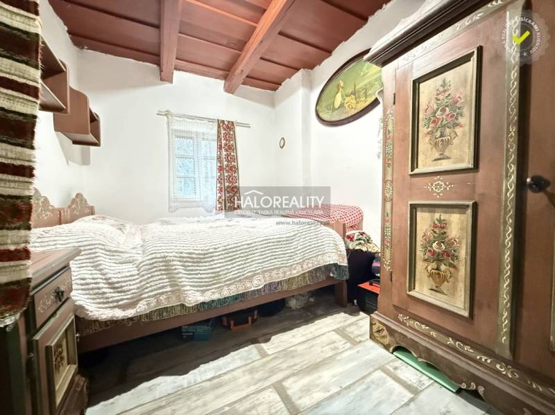 Interior of a cabin with a bed, decorated wardrobe, and floor with wooden decor.