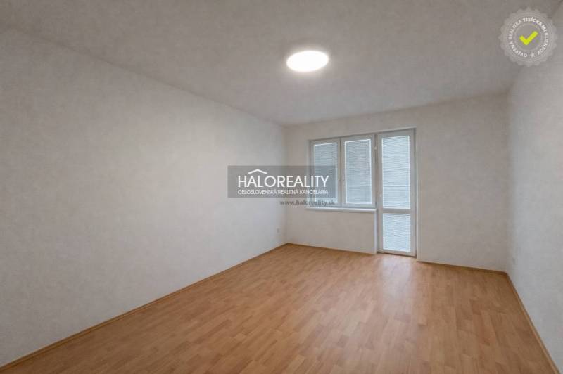 A spacious room with light walls and a floor with a wooden decor in a 4-room apartment.