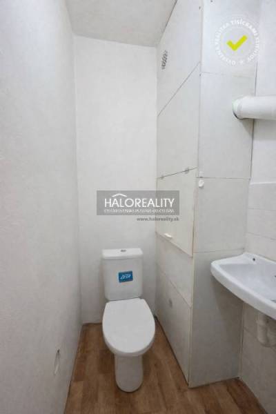 A small bathroom in a 4-room apartment with a toilet and a hanging cabinet.