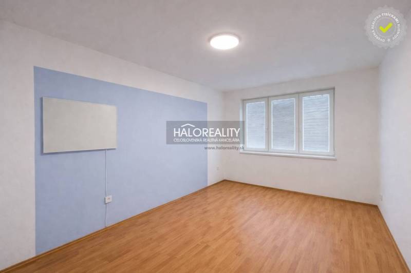 A room in a 4-room apartment with a wooden decor floor and a large window.