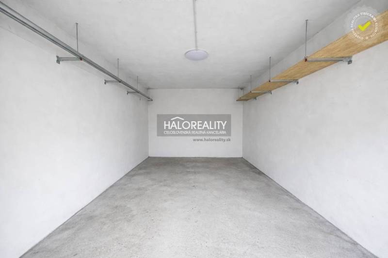 A garage space with white walls and a concrete floor, suitable for parking.