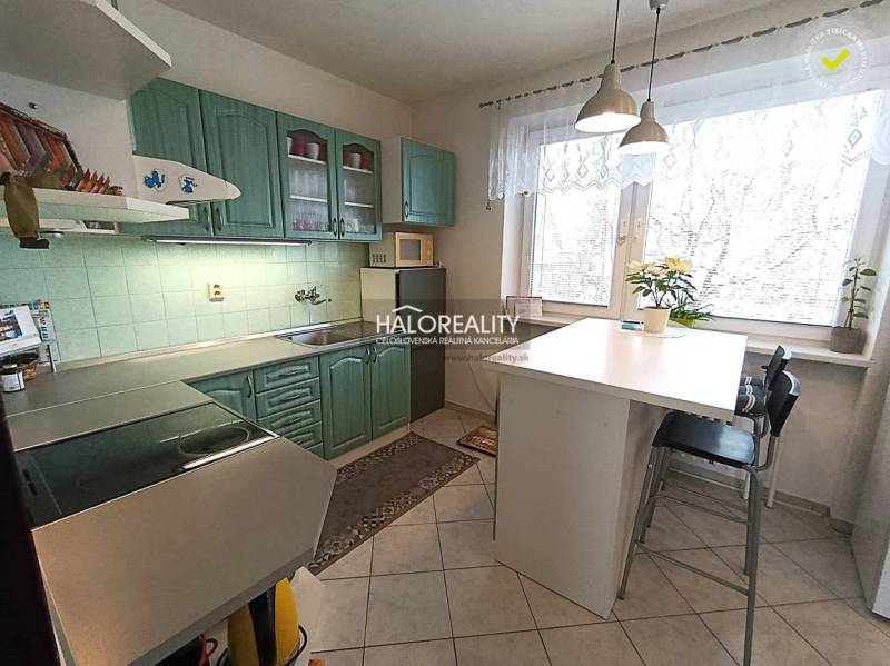 A kitchen in a family house with a tiled floor and green cabinets.