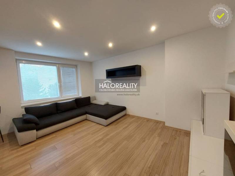Living room in a two-room apartment with a corner sofa and a wooden decor floor.