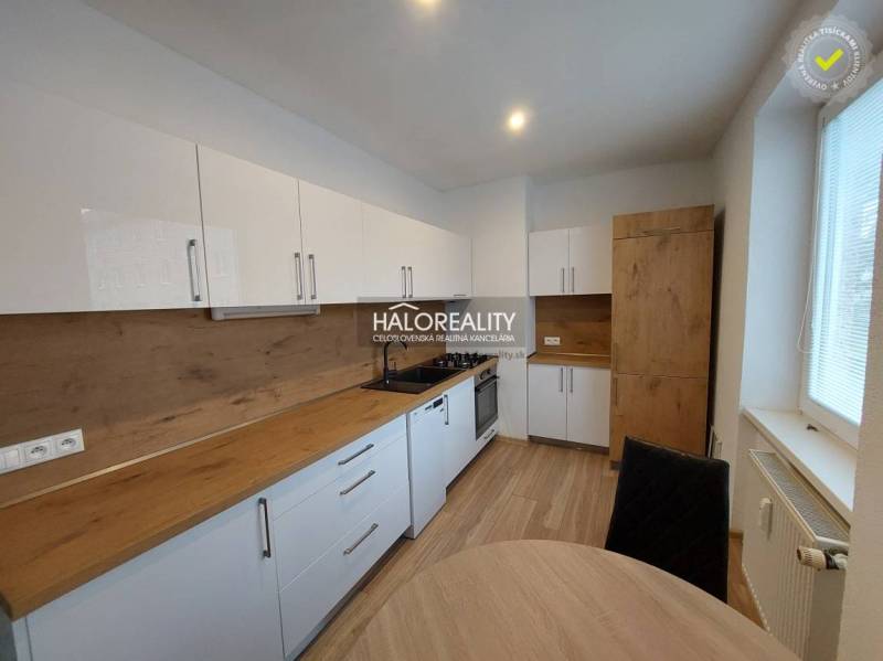 A kitchen in a 2-room apartment with a dining table and a wooden decor floor.