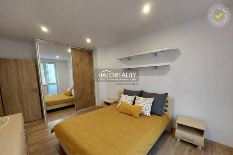 Bedroom in a 2-room apartment with wood-patterned flooring and a built-in wardrobe.