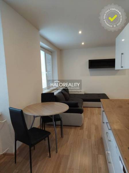 Living room in a two-room apartment with a wooden decor floor and a sofa.