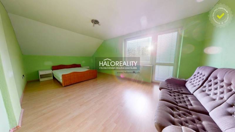 Green room in a family house with wood-patterned flooring and furniture.