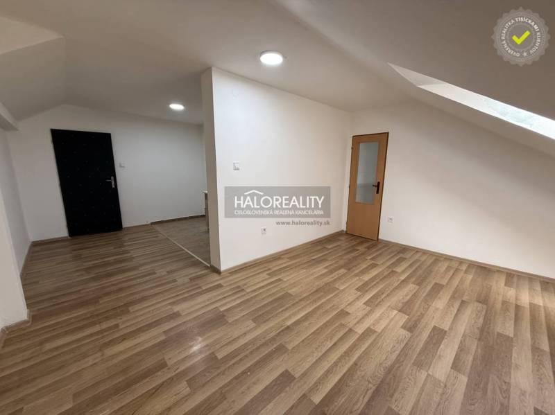 Studio apartment with wood-patterned flooring and white walls.