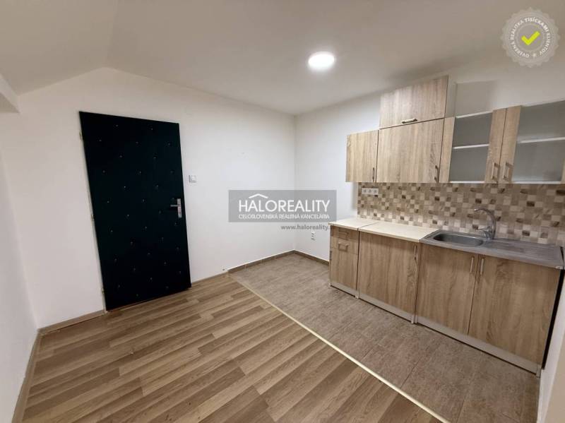 A studio apartment with a kitchen and a wooden decor floor, ideal for cozy living.