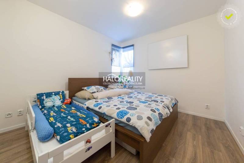 Bedroom in a 3-room apartment with a double bed and a children's bed, floor with wooden decor.