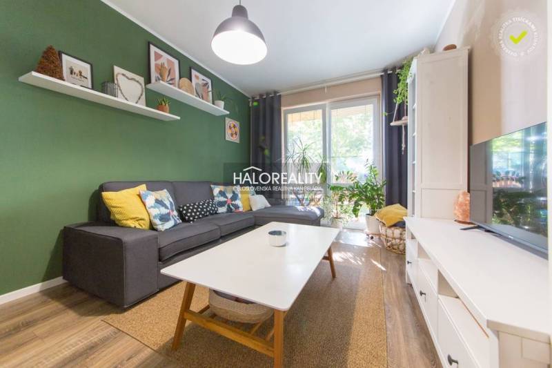 Living room in a 3-room apartment with a sofa, coffee table, and wooden decor flooring.