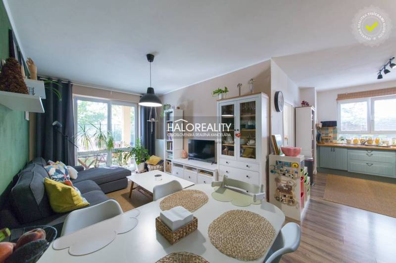 Living room in a three-room apartment with a wooden decor floor and a glass display cabinet.