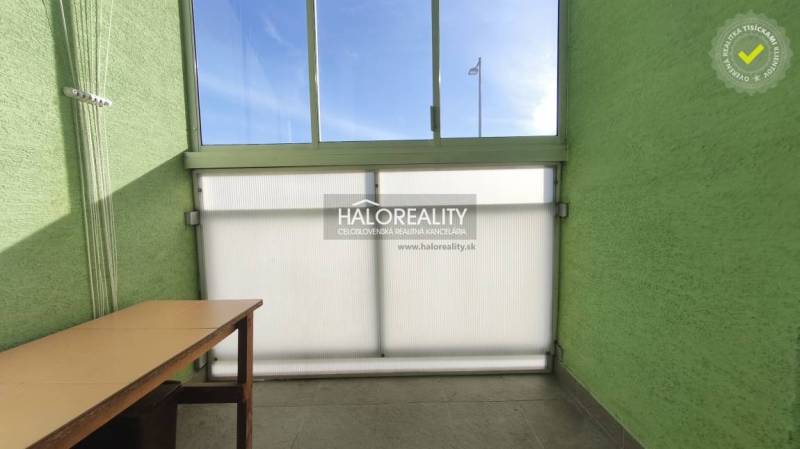 A glazed balcony in a 3-room apartment with a view and a table.