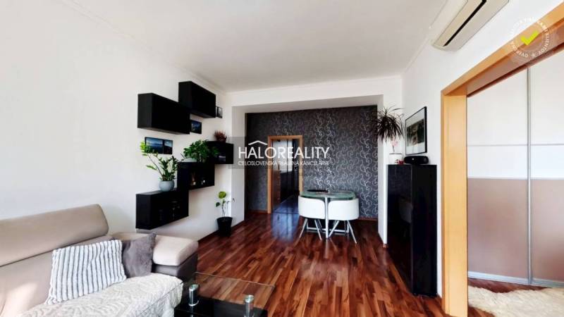 Living room in a three-room apartment with a wooden decor floor and elegant furniture.