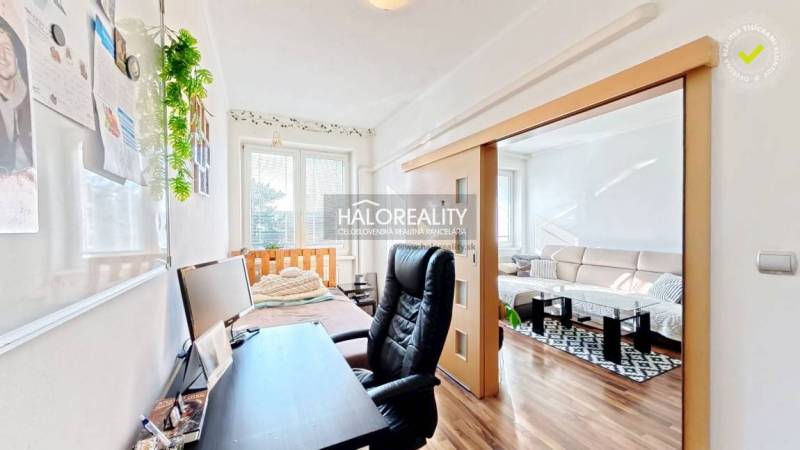A workspace with a black chair and a desk, floor with wood decor.