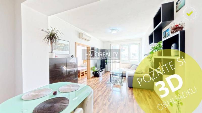 Bright living room in a 3-room apartment with wood-patterned flooring and plants.