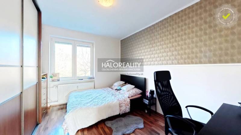 Bedroom with a bed, desk, and wooden decor flooring in a 3-room apartment.