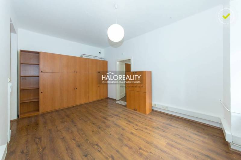 A room with a wooden floor and a large wardrobe in a five or more room apartment.