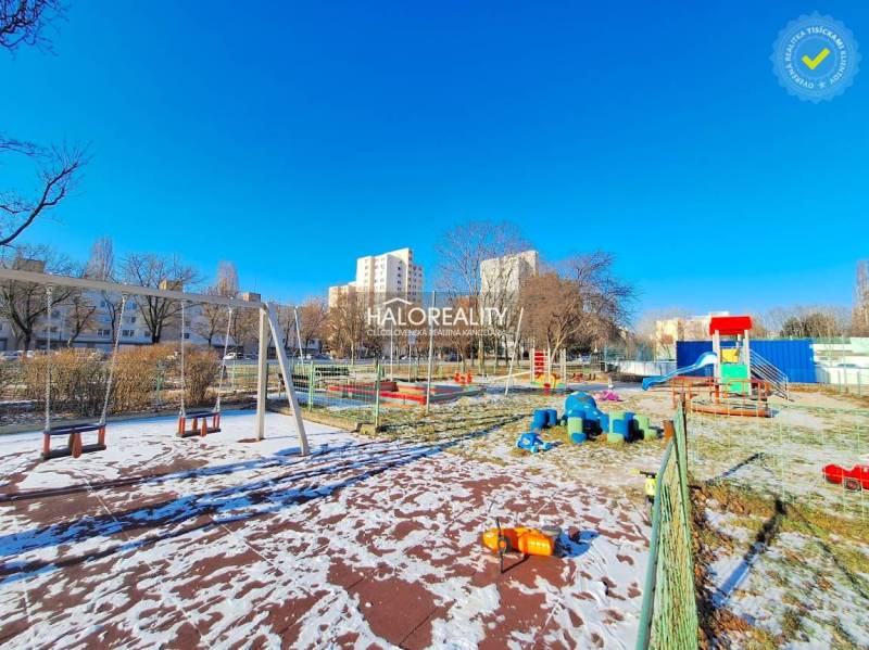 A children's playground with a slide in a snowy area in Petržalka, Bratislava.