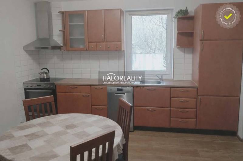 A kitchen in a family house with wooden decor, a dining table, a kitchen unit, a window.