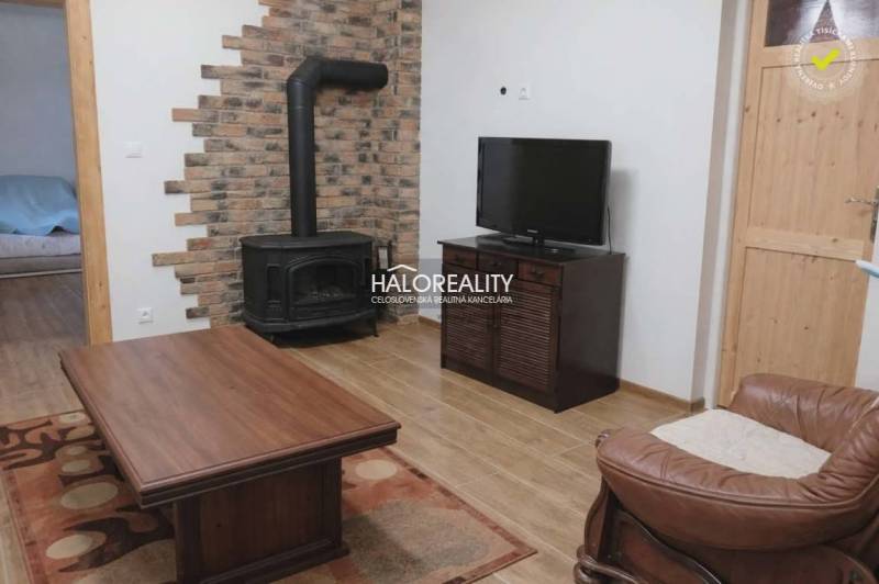 Living room in a family house with a fireplace and wooden decor flooring.