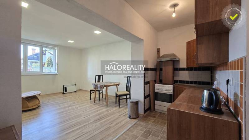A kitchen with a wooden decor floor and a dining area in a family house.