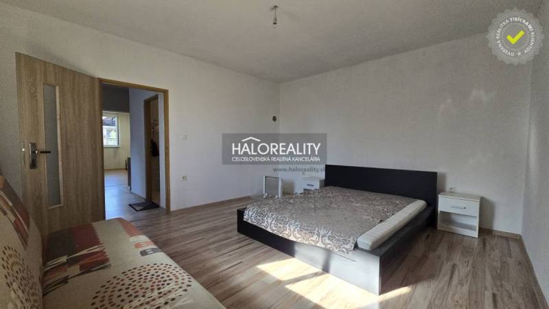 A bedroom in a family house with a bed and a wooden decor floor.
