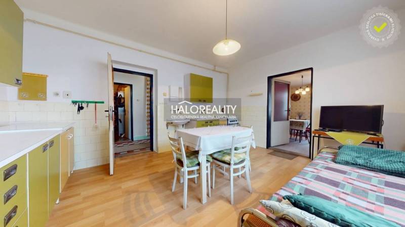 Dining room in a family house with a wooden decor floor and white furniture.