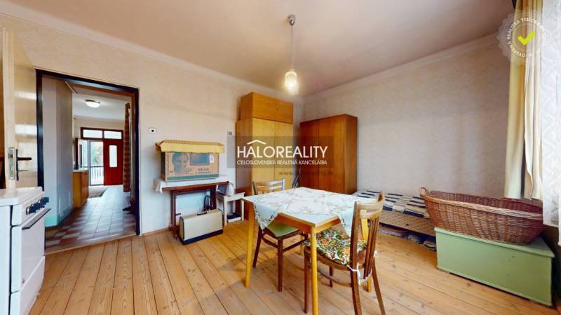 Dining room in a family house with a wooden decor floor and simple furniture.