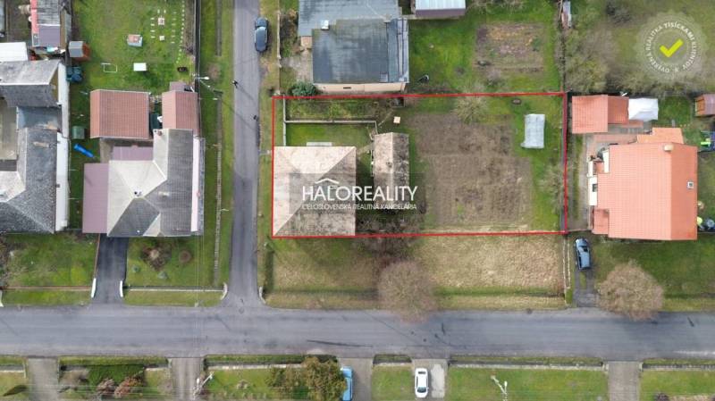 Aerial view of a family house in Tomášovce with a large plot of land, bordered by a red line.