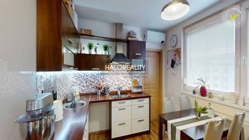 A kitchen with a dining table in a 2-room apartment with a wooden decor floor.