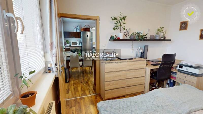 A room in a 2-room apartment with a wooden decor floor and a desk.
