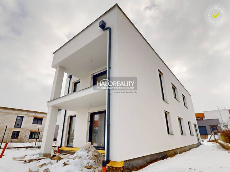 Office building in Poprad during winter, with a simple white facade, without people.