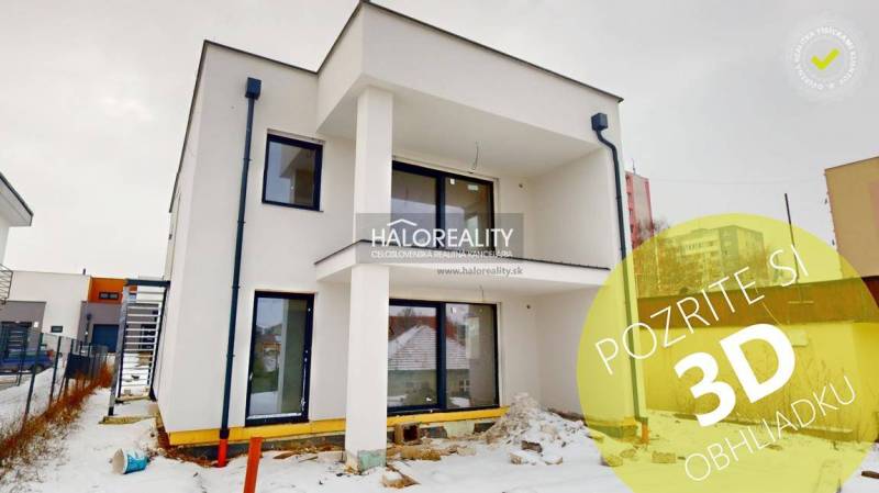 A modern two-story building with balconies in the snowy streets of Poprad, ideal for offices.