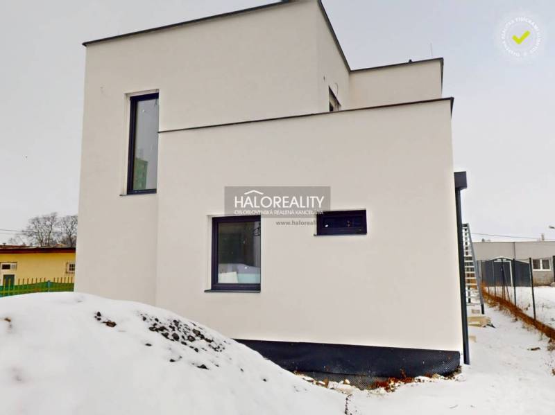 An office building in Poprad with a modern facade, covered in snow.
