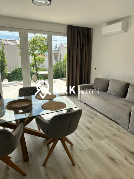 Recreational apartment with wood-patterned flooring, glass table, and sofa.