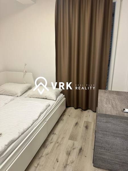 A bedroom in a holiday apartment with brown curtains and a wooden decor floor.
