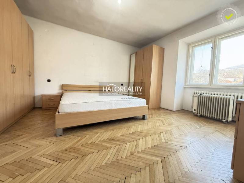 Bedroom with a bed and wardrobes in a family house with a wooden decor floor.