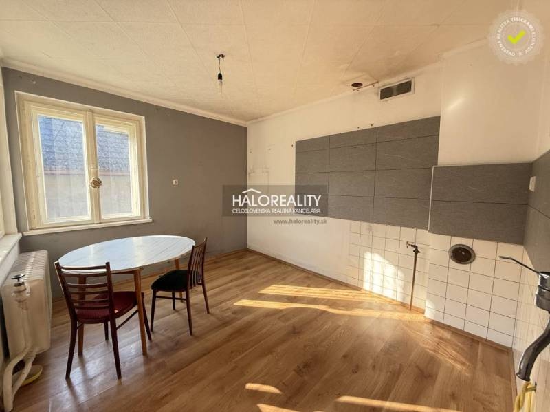 A family house kitchen with a round table and a wooden decor floor.