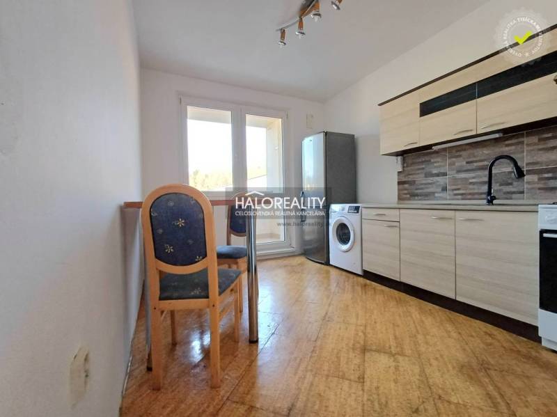 A kitchen in a 3-room apartment with a wooden decor floor and equipment.